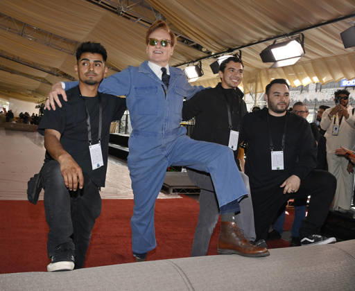 Conan O Brien strikes a pose with the crew during the 98th annual Academy Awards red carpet roll out at Ovation Hollywood in Los Angeles on Wednesday, March 11, 2026. O Brien will host the Oscars for the second consecutive year, airing live on March 15 on ABC.  LAP2026031128 JIMxRUYMEN