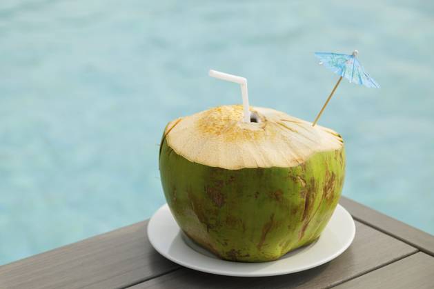 Frisches Kokosnussgetränk auf dem Tisch neben dem Pool Fresh coconut drink on the table beside the swimming pool Copyright: imageBROKER blackday ibxiqx16979489.jpg ,model released, Symbolfoto ,property released