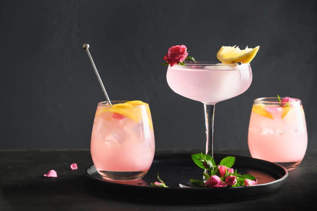 Frisches Getränk oder Limonade mit Zitrone und Rose. Freshness cocktails of rose gin with and lemon on black background. Lemonade for festive party. Summer beverage. (License=RF) Copyright: xZoonar.com SvetlanaxLazhkox 24783292