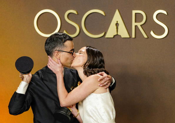 Natalie Musteata and Alexander Singh exchange a kiss during celebrations in the press photo room after winning the Best Live Action Short Film Oscar for Two People Exchanging Saliva during the 98th annual Academy Awards in the Hollywood section of Los Angeles on Sunday, March 15, 2026. Conan O Brien is hosting the Oscars for the second consecutive year.  LAP20260315350 BONNIExCASH