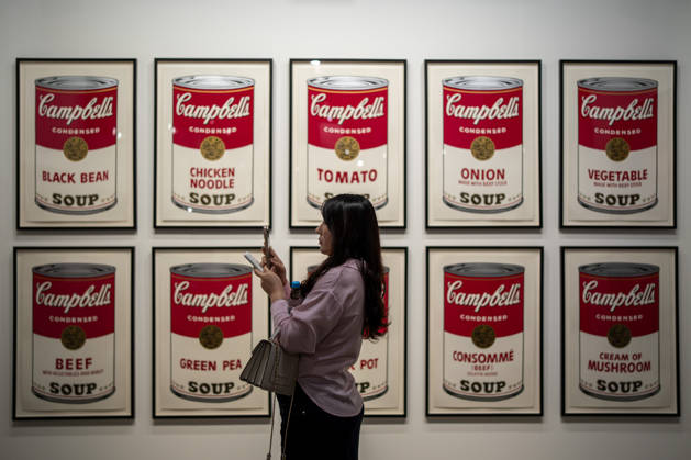 HONGKONG-ART ART-BASEL A woman taking a photo with her phone in front of Campbell s Soup Cans drawings at Art Basel 2026 in Hong Kong, March 26, 2026. NEXPHER Vernon Yuen HONG KONG