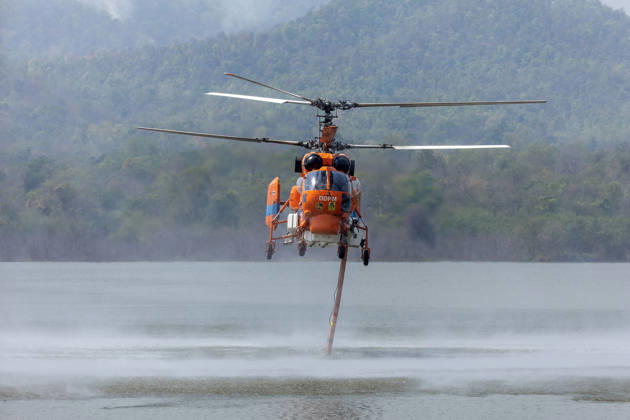 March 27, 2026, Chiang Mai, Thailand: A helicopter performs water pickup operations over a reservoir in Chiang Mai, northern Thailand, as part of aerial firefighting efforts against ongoing wildfires. A KA-32 helicopter from the Department of Disaster Prevention and Mitigation skims the water surface to collect water before heading to fire-affected forest areas amid hazy conditions caused by smoke and rising PM2.5 pollution. Chiang Mai Thailand  - ZUMAs197 20260327_aaa_s197_339 Copyright: xPongmanatxTasirix