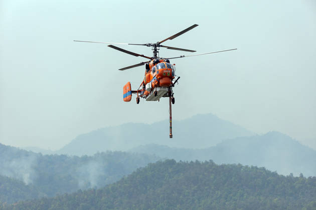 March 27, 2026, Chiang Mai, Thailand: A KA-32 helicopter from the Department of Disaster Prevention and Mitigation conducts aerial firefighting operations over mountainous forest areas in Chiang Mai, northern Thailand, carrying a water bucket while flying through smoke-filled valleys as authorities battle ongoing wildfires and severe PM2.5 air pollution. Chiang Mai Thailand - ZUMAs197 20260327_aaa_s197_343 Copyright: xPongmanatxTasirix
