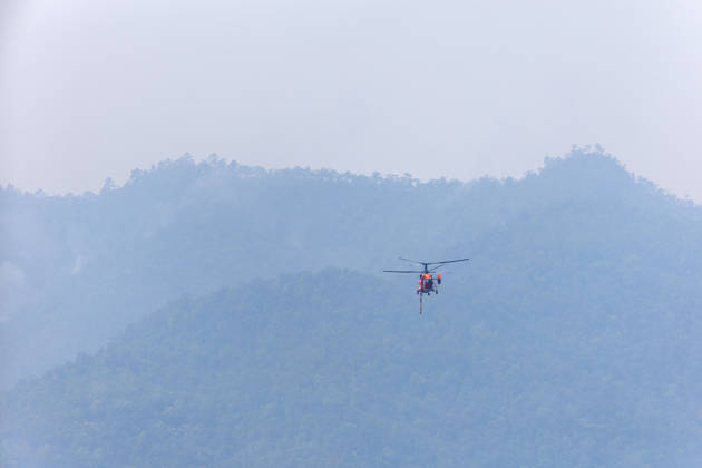 March 27, 2026, Chiang Mai, Thailand: A KA-32 helicopter from the Department of Disaster Prevention and Mitigation conducts aerial firefighting operations over mountainous forest areas in Chiang Mai, northern Thailand, carrying a water bucket while flying through smoke-filled valleys as authorities battle ongoing wildfires and severe PM2.5 air pollution. Chiang Mai Thailand - ZUMAs197 20260327_aaa_s197_352 Copyright: xPongmanatxTasirix