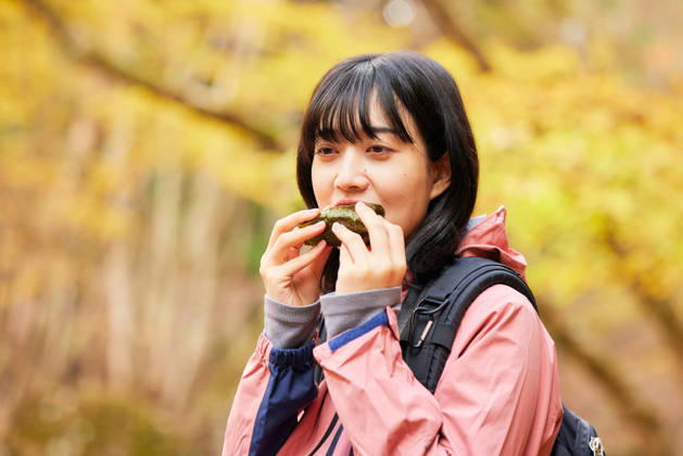 IMAGO Creative, Food, Japan, Onigiri Young Japanese woman refueling with a rice ball on an autumn hike AFLO316841519  316841519 ,model released, Symbolfoto