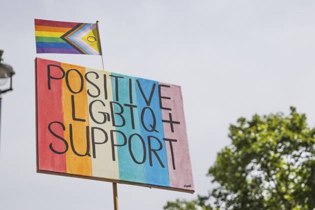 Aufmunterndes Regenbogenplakat mit der Aufschrift Positive LGBTQ Unterstützung mit einer Progress Pride Flagge, die Verbündete, Gleichheit und Inklusion bei einer friedlichen Parade oder Gemeinschaftskundgebung symbolisiert Uplifting rainbow placard reading Positive LGBTQ Support with a Progress Pride flag, symbolizing allyship, equality and inclusion at a peaceful parade or community rally Copyright: imageBROKER Tartezy ibliqx17103162.jpg