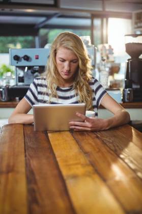 Woman sitting in a cafe using digital tablet Thoughtful woman sitting in a cafe using digital tablet, model released, , property released, Cape Town, South Africa, 30.05.2016, 797480.jpg, table, cafe, coffee shop, cafeteria, restaurant, hotel, casual clothing, sitting, holding, serious, thoughtful, web, internet, touching, reading, scrolling, digital tablet, tablet computer, tablet pc, touchscreen, wireless technology, communication, connection, lifestyle, leisure, pretty, attractive Indoors,Day