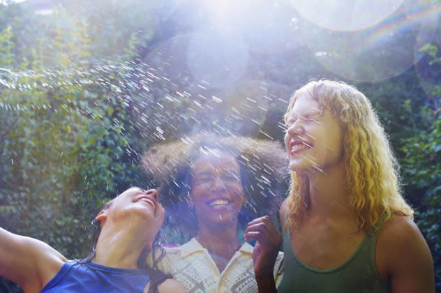 IMAGO Creative, Jahreszeit Sommer, Regen, Sommerregen Happy people enjoying water splash outdoors on a bright summer day model released, Symbolfoto, AZF00935