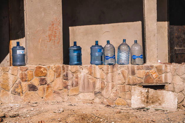 Marsa alam, egypt 21 april 2026: water bottles are lined up on a stone wall, representing hydration and resource management in a warm, dry desert region Water bottles stored in outdoor desert environment, marsa alam Copyright: xx Egitto edit 859