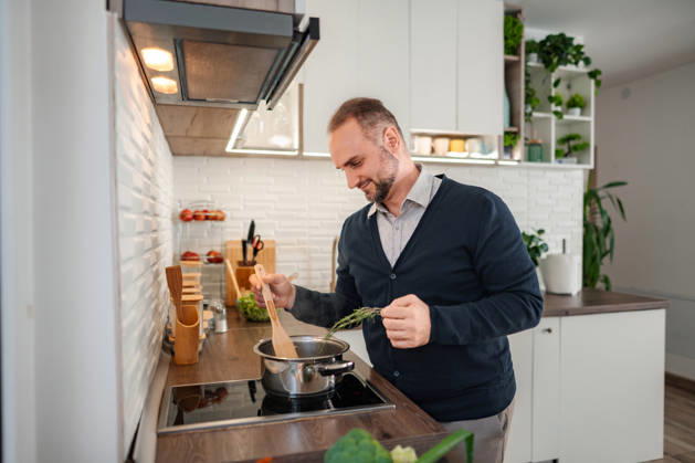 Ein glücklicher Mann, der in der Küche kocht und frische Kräuter hinzufügt Ein glücklicher Mann, der in der Küche kocht und frische Kräuter hinzufügt (License=RF) ,model released, Symbolfoto Copyright: xZoonar.com JelenaxCvetkovicx 24966994 ,model released, Symbolfoto ,property released