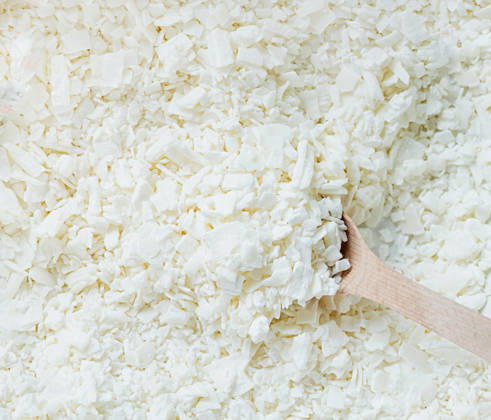 Nahaufnahme eines Holzlöffels in weißen Sojawachsflocken Creative hobby of candle making at home. closeup of wooden spoon in white soy wax flakes. Natural soywax texture (License=RF) Copyright: xZoonar.com ILONAxSHOROKHOVAx 24990949