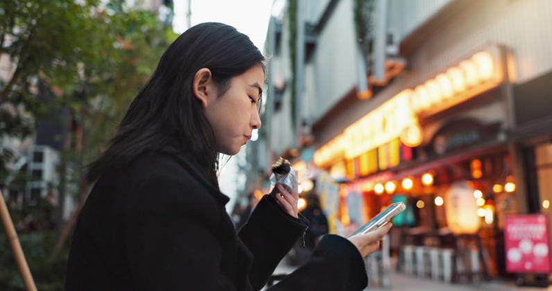 IMAGO Creative, Food, Japan, Onigiri Phone, eating and Asian woman with onigiri in the city on exploring vacation, adventure or holiday. Hungry, food and young female person enjoying a Japanese snack or meal in town on weekend trip (License=RF) ,model released, Symbolfoto  Copyright: xZoonar.com YurixArcursxpeopleimages.comx 21199914 ,model released, Symbolfoto ,property released