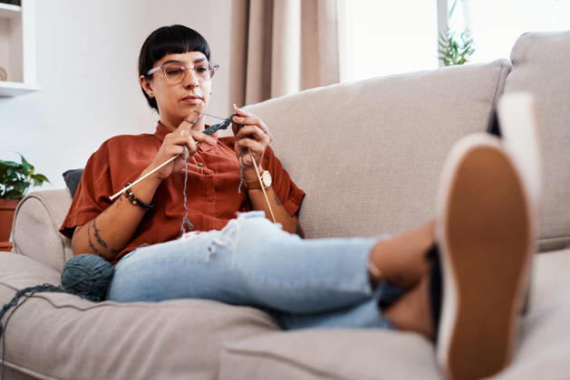 Relax, woman and knitting in living room for craft, hobby and creative in home for fashion. Designer, female person and sewing or crochet on weekend in apartment with yarn, pride and cotton on sofa. (License=RF) ,model released, Symbolfoto  Copyright: xZoonar.com YurixArcursxpeopleimages.comx 21843434 ,model released, Symbolfoto ,property released