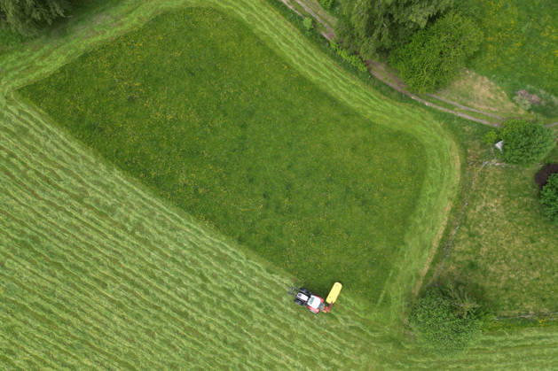 Aerial view spring spring in Siegerland A lush green meadow is mowed by a tractor with a mower mower near Siegen Oberschelden spring spring in Siegerland on 23 05 2026 in Siegen Germany