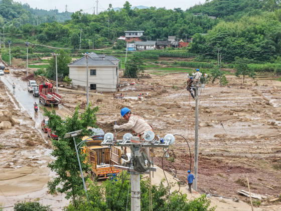 (260526) -- CHONGQING, May 26, 2026 -- A drone photo taken on May 26, 2026 shows staff members of State Grid Chongqing Yongchuan Power Supply Company repairing power supply lines at Anxi Village of Yongchuan District, southwest China s Chongqing Municipality, May 26, 2026. From Saturday night to early Sunday morning, a sudden and extreme catastrophic rainstorm struck Yongchuan, triggering flash floods and geological disasters in multiple areas of this district. After the disaster occurred, the local authorities immediately activated the emergency response mechanism, coordinated rescue forces from all sides and made every effort to carry out rescue operations and infrastructure restoration. Rescue and response efforts are still under
