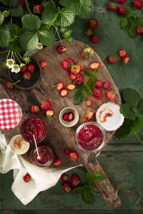 Flat lay of home made fresh strawberries jam in glass containers on wooden table and strawberry plants Flat lay of home made fresh strawberries jam in glass containers on wooden table and strawberry plants Copyright: xMonicaxBertolazzix MB130526-10
