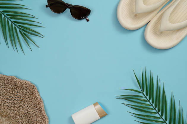 Sommerurlaub-Flatlay mit Sonnenbrille, Flip-Flops und Palmblättern A vibrant flat lay of summer vacation items including sunglasses, flip flops, and palm leaves on a light blue background. (License=RF) Copyright: xZoonar.com WORAWEExMEEPIANx 25112671