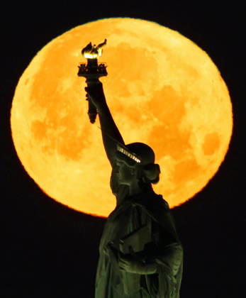 A rare Blue Moon, the second full moon to appear in the sky in a single month, sets behind the Statue of Liberty on Sunday, May 31, 2026 in New York City.  NYP20260531103 JOHNxANGELILLO