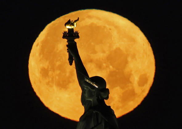 A rare Blue Moon, the second full moon to appear in the sky in a single month, sets behind the Statue of Liberty on Sunday, May 31, 2026 in New York City.  NYP20260531105 JOHNxANGELILLO