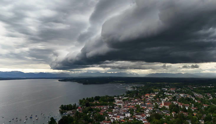 An early summer day in Tutzing, Starnberg district Here the view over the village and Lake Starnberg with the Alps on the horizon, where a thunderstorm is just coming up, a wall of clouds, thunderstorm roll, cloud roll, thunderstorm front, thunderstorm roll, thunderstorm front, dark clouds, weather picture