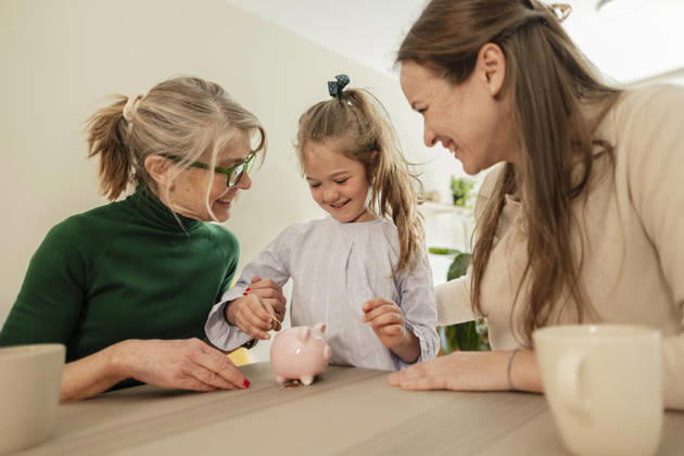 Smiling mother and grandmother teach daughter saving money indoors model released, Symbolfoto property released, JCCMF15274