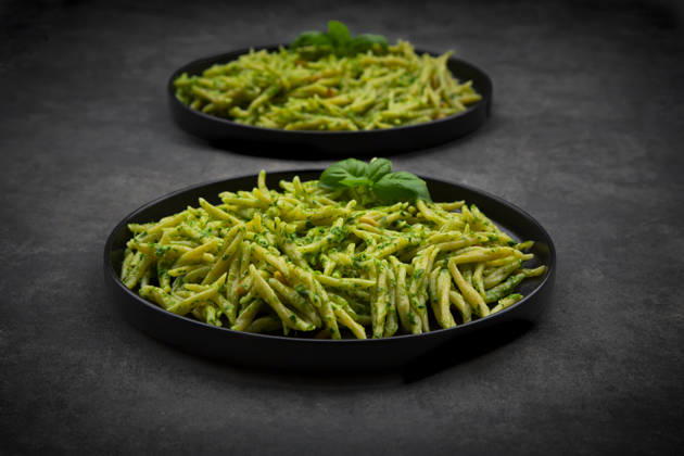 Trofie pasta with genovese pesto and basil on black plates, LVF09719