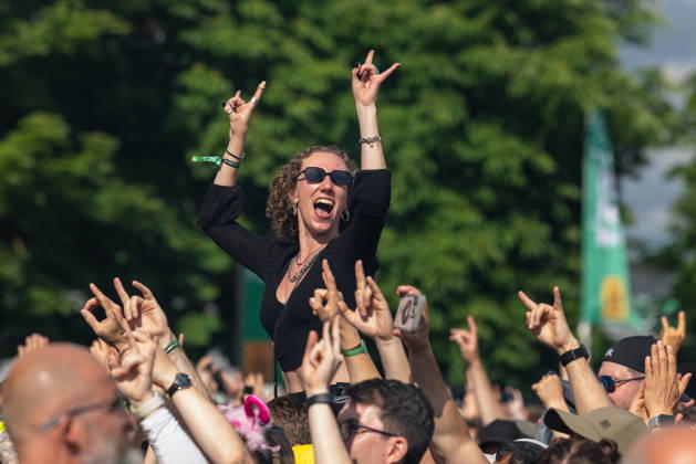 Music festival Rock im Park 2026 THREE DAYS GRACE, Nuremberg, 05 06 2026 Cheering festival visitor with raised arms and devil horns in the middle of the crowd during the performance of Three Days Grace Fans celebrate the Canadian hard rock band in summery weather on the Zepplinfeld Nuremberg Bavaria Germany 20260605-1V9A9454-M4000