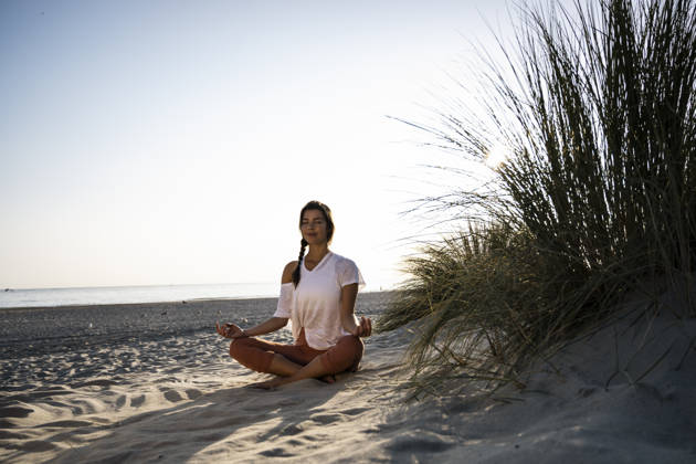 Woman practicing yoga and meditating on a sandy summer beach model released, Symbolfoto, UUF36836