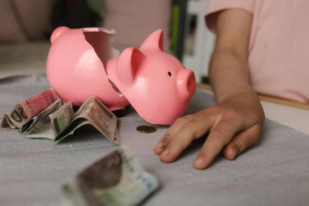 Hand reaching for cash next to a broken pink piggy bank model released, Symbolfoto property released, VIVF01837