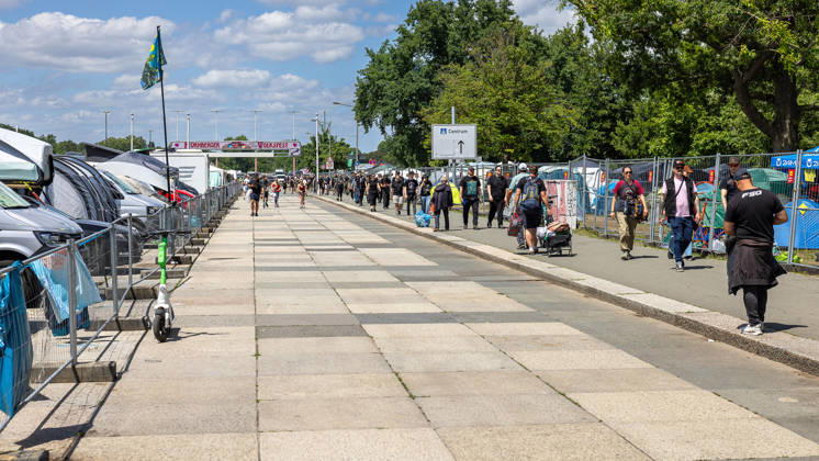 Music festival Rock im Park 2026, Nuremberg, 07 06 2026 Visitors of the Rock im Park festival walk on the Große Straße on the Reichsparteitagsgelände towards the festival center A banner of the Nuremberg folk festival is visible in the background Nuremberg Bavaria Germany 20260607-286A8397-M4000