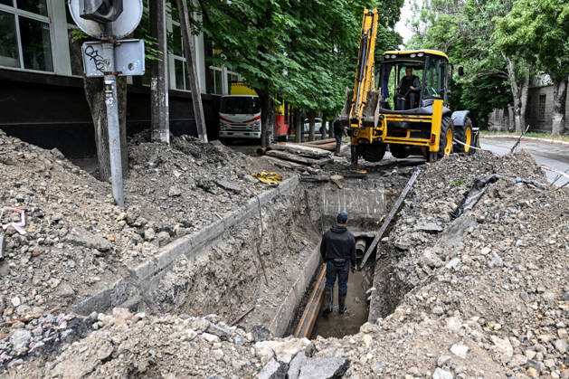RECORD DATE NOT STATED Municipal workers repair utility pipelines in the red zone of the frontline city of Kherson, the area considered the most dangerous due to constant Russian attacks, Kherson, Ukraine, on June 3, 2026. The Russian army attacks the city daily with FPV drones and other unmanned aerial vehicles, deliberately terrorizing civilians. Russian forces conduct hunts for local residents, tracking them with FPV drones and dropping explosives. Police officers, medics, public transport, and urban infrastructure are also targeted. Based on the intensity of attacks, Kherson is informally divided into yellow and red zones, with the red zone subjected to continuous shelling and drone strikes. Anti-drone netting has been installed above roads to help Copyright: xDmytroxSmolienkox