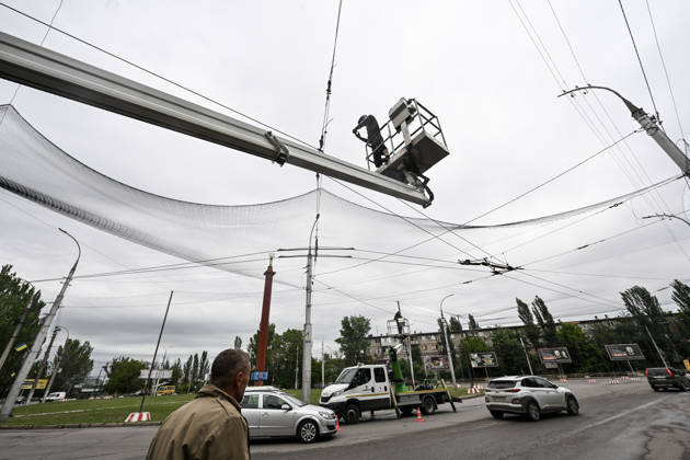 RECORD DATE NOT STATED A municipal worker installs anti-drone netting to protect against Russian FPV drones in the yellow zone of the frontline city of Kherson, Ukraine, on June 3, 2026. The Russian army attacks the city daily with FPV drones and other unmanned aerial vehicles, deliberately terrorizing civilians. Russian forces conduct hunts for local residents, tracking them with FPV drones and dropping explosives. Police officers, medics, public transport, and urban infrastructure are also targeted. Based on the intensity of attacks, Kherson is informally divided into yellow and red zones, with the red zone being the most dangerous due to constant shelling and drone strikes (Photo by Dmytro Smolienko Ukrinform) Life under shelling in frontline Kherson Copyright: xDmytroxSmolienkox