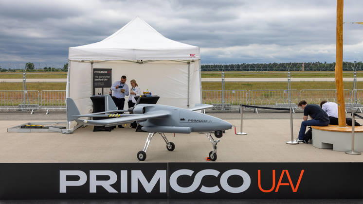 Trade visitor day at ILA Berlin 2026, Berlin, 12 06 2026 An unmanned aerial vehicle UAV from the Czech manufacturer Primoco UAV stands on the exhibition grounds The model is advertised as the worlds first certified UAV with NATO STANAG and EASA approval according to the stand sign In the background, two stand employees in conversation Schöneber 20260612-286A9704-M4000