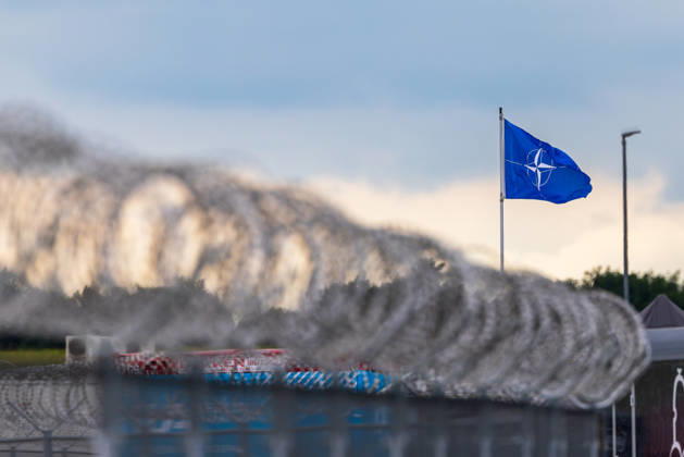 Trade visitor day at ILA Berlin 2026, Berlin, 12 06 2026 A NATO flag flies in the wind behind a barbed wire barrier Concrete barriers with red and white markings can be seen in the foreground Schöneberg Berlin ExpoCenter Airport Brandenburg Germany 20260612-1V9A1902-M4000