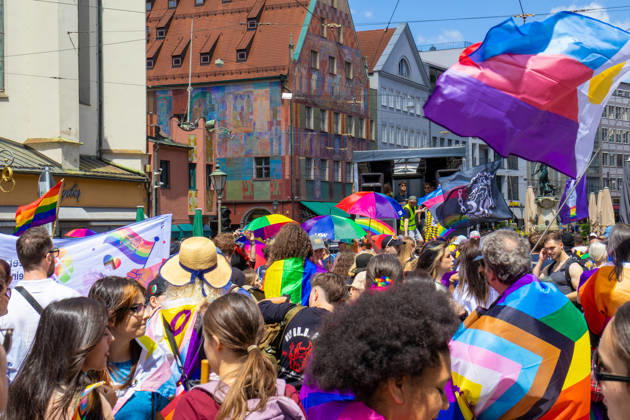 Augsburg, Bavaria, Germany June 13, 2026: Participants carrying rainbow flags and wearing colorful costumes take part in Christopher Street Day (CSD) in Augsburg. The parade through the city center promotes the rights of LGBTQ+ people as well as social diversity and tolerance. Several participants carry various Pride and identity flags
