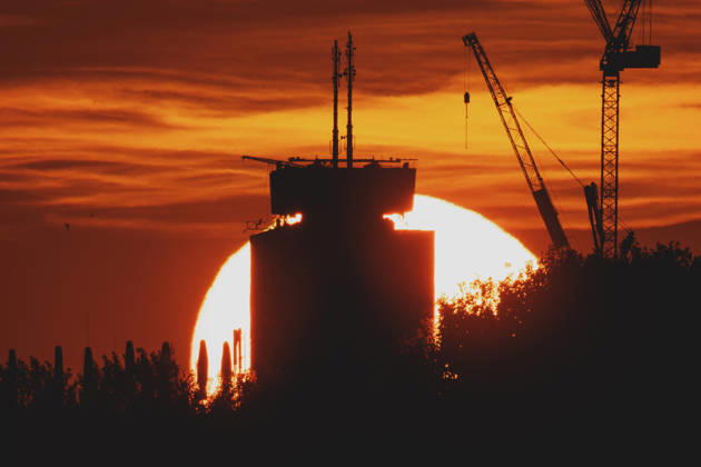 The setting sun is visible behind a new building with a crane in Berlin, June 19, 2026. A heat wave is currently affecting all of Germany. Berlin, Germany,detected_source_language Copyright: xFlorianxGaertnerx