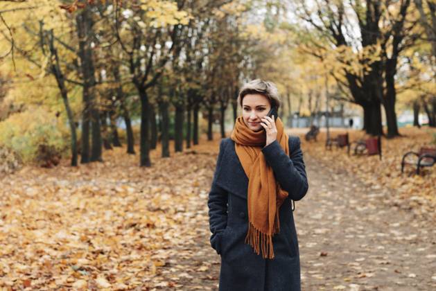 Kurzhaarige blonde Frau kommuniziert am Telefon und geht in Mantel und Schal im Herbstpark spazieren Short-haired blonde woman communicates on the phone walking in the autumn park in a coat and scarf Copyright: imageBROKER TatsianaxKalasouskay ibxmdz17887735.jpg ,model released, Symbolfoto ,property released