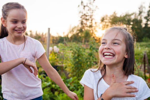 Two young sisters laughing together outdoors at sunset Langley, British Columbia, Canada CR_JDIP260630-2071821-01 ,model released, Symbolfoto
