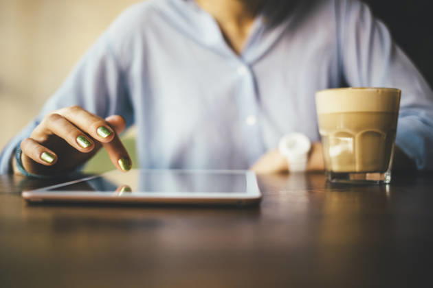 Woman sitting in a cafe using a digital tablet and drinking a coffee model released, Symbolfoto, OYF00054