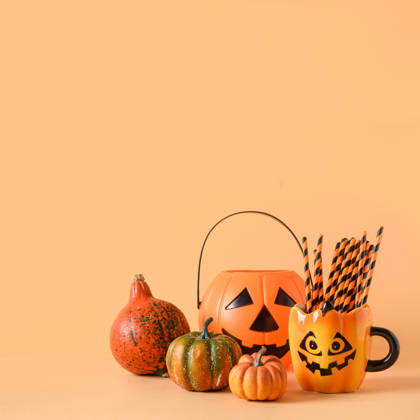 Lustige Halloween-Partydekoration, Kürbisse, Becher mit Trinkhalm. Halloween festive party decorations, candy bowl, pumpkins, funny mug with drinking straw on orange background. Square composition with copy space. (License=RF) Copyright: xZoonar.com SvetlanaxLazhkox 25303778