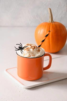 Halloween-Kürbis-Latte mit Schlagsahne und Spinnen als Garnitur Pumpkin latte coffee with whipped cream decorated spiders in orange mug on white kitchen background. Vertical format. Funny food for child in Halloween party. (License=RF) Copyright: xZoonar.com SvetlanaxLazhkox 25303864