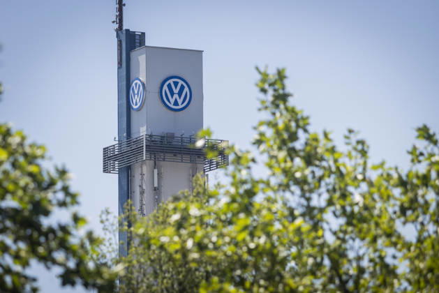 Tower at the VW plant in Osnabrück with the VW logo against a blue sky, framed by the foliage of green trees; stock photo: Volkswagen Osnabrück, July 11, 2026; stock photo: VW Osnabrück