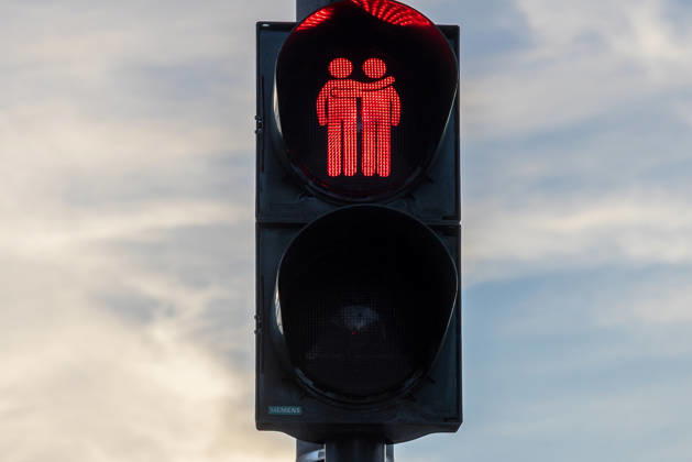 Traffic light designs featuring same-sex couples as a symbol of diversity, Erlangen, August 7, 2026 A pedestrian traffic light displays a same-sex couple in red as a symbol of diversity and tolerance. The design of the Siemens traffic light system is illuminated against a cloudy sky. Erlangen Research Center, Bavaria, Germany 20260807-286A4441-M4000