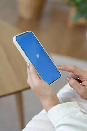 Handy mit neuem ?X?-Logo für Twitter auf blauem Hintergrund mit weißem Vogel; Elon Musk verspricht, das Vogel-Logo abzuschaffen mobile phone with new logo X for twitter on blue background with white bird, Elon Musk vows to ditch bird logo. (License=RM) Copyright: xZoonar.com WICHAYADAxSUWANNACHUNx 25405299