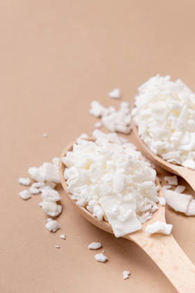 Sojawachs in einem Holzlöffel auf braunem Hintergrund, Kopierraum Soy wax for home-made natural white soy wax candles. Closeup of soy wax in wooden spoon on brown background, copy space (License=RF) Copyright: xZoonar.com IlonaxShorokhovax 25414762
