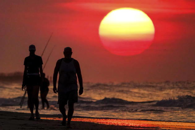 August 12, 2026, Isle Of Palms, Sc, United States: People silhouetted by the sunrise, walk along the beach as the massive ball rises over the Atlantic Ocean, August 12, 2026 in Isle of Palms, South Carolina. The Charleston area is currently under a heat advisory with temperatures in the 90Ã¢â‚¬â ¢s and a heat index of 115-degrees. Isle Of Palms United States - ZUMAe02_ 20260812_zaf_e02_005 Copyright: xRichardxEllisx