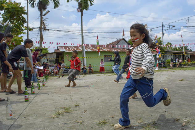 Indonesia s 81st Independence Day Festive Determination - Medan Children participate in the Lomba Balap Kelereng (marble race) to celebrate Indonesian Independence Day on August 17, 2026. One girl balances a marble on a spoon in her mouth, hands behind her back, focusing on not dropping it. In the background, other children race while residents of Neighborhood IV in Karang Sari village, Medan Polonia, North Sumatra, watch the event. Photo by Aditya Sutanta ABACAPRESS.COM Medan Indonesia  Copyright: xAdityaxSutanta ABACAx