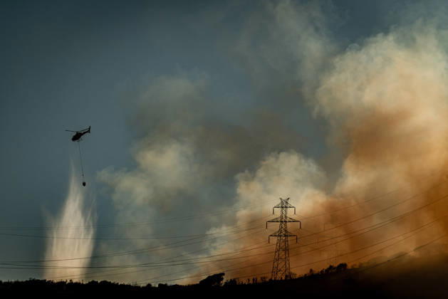 August 25, 2026, Barcelona, Spain: A helicopter drops water on a wildfire burning in the Collserola mountain range in Barcelona as thick smoke rises over the hills. The fire has affected the city s Nou Barris district, prompting authorities to evacuate and shelter residents in the Torre Baro and Ciutat Meridiana neighborhoods. Barcelona Spain  - ZUMAb137 20260825_fap_b137_017 Copyright: xJordixBoixareux