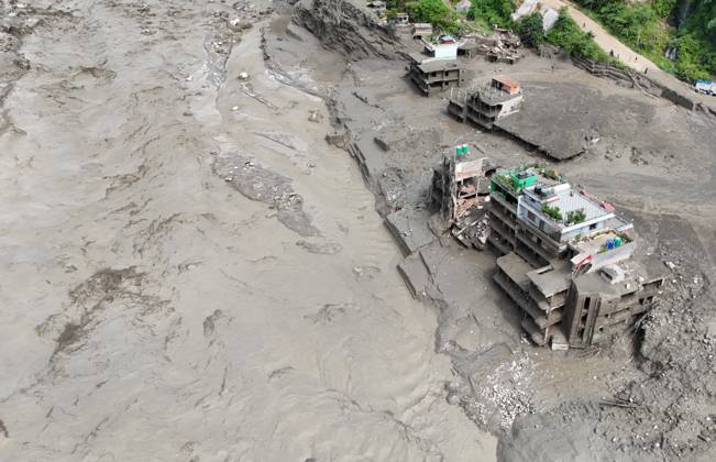 August 26, 2026, Nuwakot, Nepal: An aerial view shows buildings and infrastructure damaged along the swollen Trishuli River following a massive flash flood triggered by an avalanche of ice and rock in the upper Lhende River on the Tibetan side, in Nuwakot district, Nepal, on Wednesday, August 26, 2026. The sudden flood swept through communities along the Bhote Koshi and Trishuli river systems, destroying homes, roads and bridges and leaving widespread devastation downstream. Nuwakot Nepal  - ZUMAg200 20260826_zap_g200_017 Copyright: xSkandaxGautamx