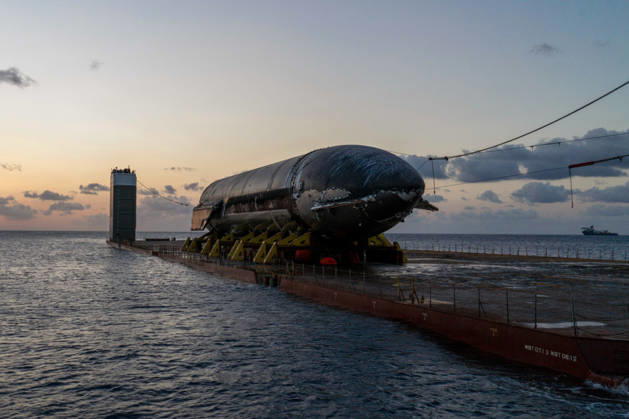 SpaceX engineers spent several days inspecting Ship 40 in the waters off Christmas Island as seen in pictures released on Thursday, August 27, 2026. They collected heatshield samples and gained vital insight into how the vehicle handled reentry, with improvements now planned for future vehicles. Starship has now been loaded onto a semi-submersible ship to begin the several-month journey back to Starbase.  WAX2026082708 SPACEX